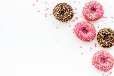 Renkli çörekler pembe ve çikolatalı krema. Fırının düz yatağı, yukarısı manzaralı.