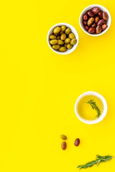 Olive oil in bowl near oilves from above copy space