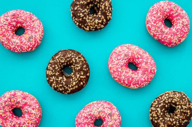 Donutlar mavi arkaplanda düz konum deseni, üst görünüm