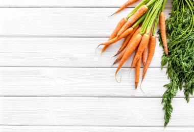 Fotokopi alanının üzerinde yeşil başlıklı taze havuçlar var.