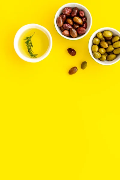 Olive oil in bowl near oilves from above copy space