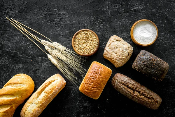 Bakery. Fresh bread in assortment on yellow table top-down — Stock Photo, Image