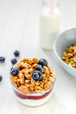 Sağlıklı bir sabah, beyaz mutfak masasında granola kahvaltısı.