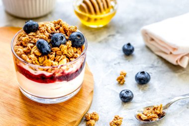 Mutfak masasında müsli ve böğürtlenli yoğurttan sağlıklı bir kahvaltı.