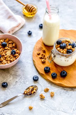 Sabah kahvaltısı yoğurt, bal ve böğürtlen beyaz masada.