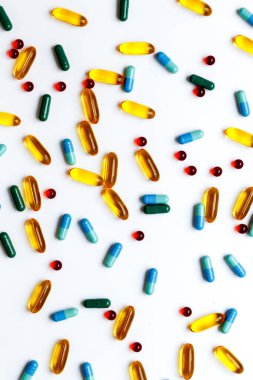 Beyaz arka planda izole edilmiş renkli tıbbi haplar.