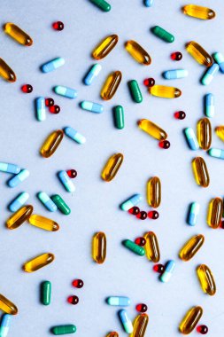 Gri arka planda izole edilmiş renkli tıbbi haplar.