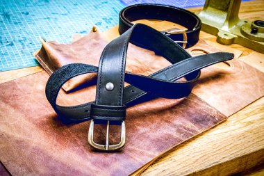 Masanın önündeki deri atölye kemeri.