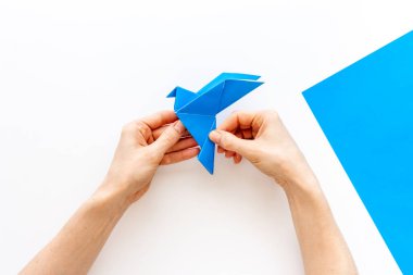 Origami kuşu dişi ellerde. Barışa önem ver. Üst görünüm