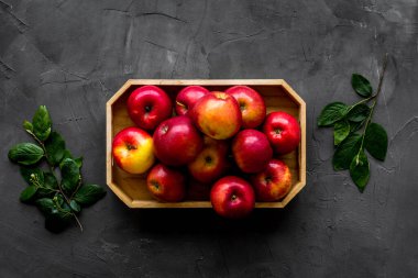 Tahta tepside yapraklı kırmızı elmalar grubu. Sonbahar hasadı