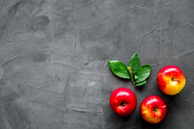 Mutfak masasında yeşil yapraklı kırmızı elmaların üst görüntüsü