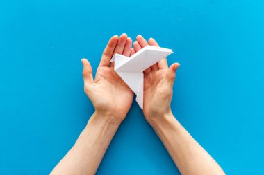 Origami kuşu dişi ellerde. Barışa önem ver. Üst görünüm