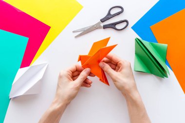 Kağıt katlayan kadın elleri - origami kuşu. Genel Görünüm