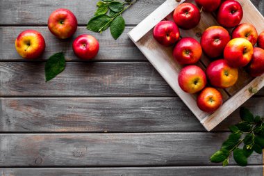 Tahta tepside yapraklı kırmızı elmalar grubu. Sonbahar hasadı
