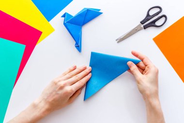 Kağıt katlayan kadın elleri - origami kuşu. Genel Görünüm