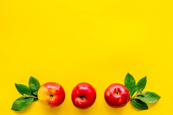 Draufsicht auf rote Äpfel mit grünen Blättern auf dem Küchentisch — Stockfoto