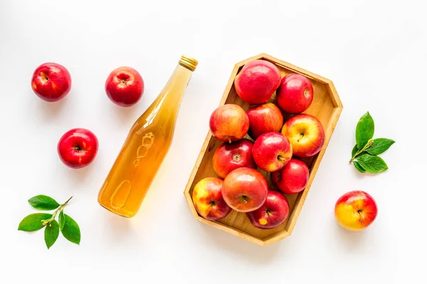 Vinagre de sidra de manzana en botella de vidrio y bandeja de madera con manzanas rojas — Foto de Stock