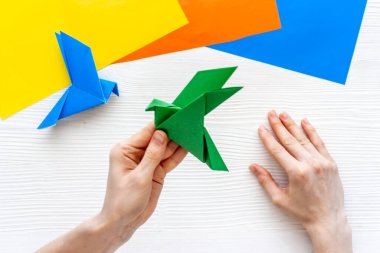 Origami kuşu dişi ellerde. Barışa önem ver. Üst görünüm