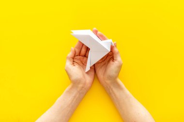 Origami kuşu dişi ellerde. Barışa önem ver. Üst görünüm