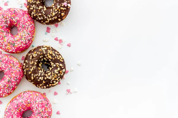 Colorful donuts pink and chocolate icing. Flat lay of bakery, above view — Stock Photo, Image