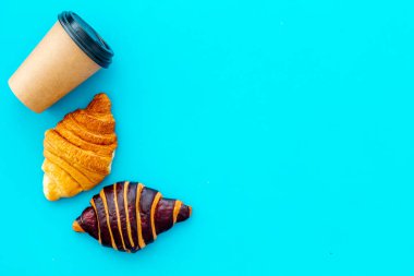 Kahveli kruvasan. Kahvaltınız mavi taş masanın üstünde.