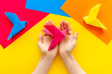 Origami kuşu dişi ellerde. Barışa önem ver. Üst görünüm