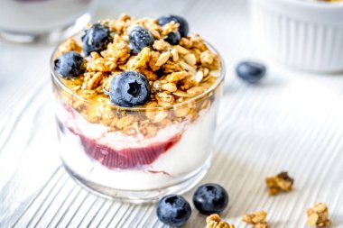 Beyaz mutfak arka planında yoğurt ve böğürtlenli sabah kahvaltısı.