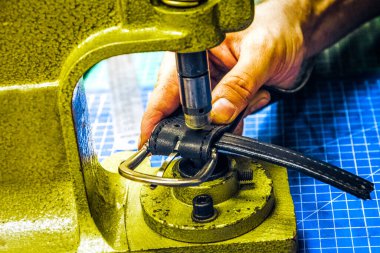 Deri atölye ustası kemeri kavradı ve toka taktı