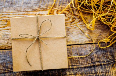 Rafya ya da sicimle ahşap masadaki el işi hediye kutusu.