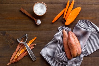 Kesme tahtasında çiğ portakallı tatlı patates, üst manzara.