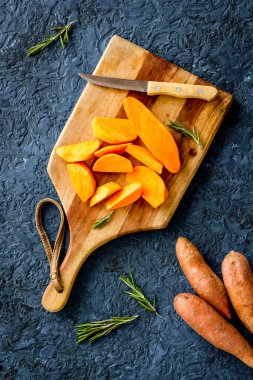 Kesme tahtasında dilimlenmiş tatlı patates, üst manzara.
