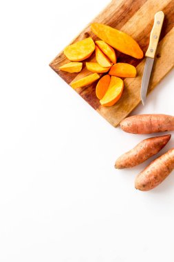 Kesme tahtasında dilimlenmiş tatlı patates, üst manzara.