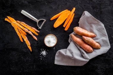 Kesme tahtasında çiğ portakallı tatlı patates, üst manzara.