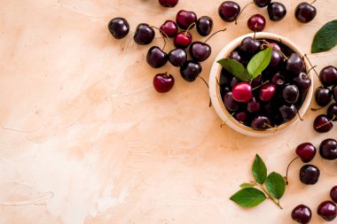 Tahta kasede yaprakları olan kırmızı kirazlar. Düzen, böğürtlen arka planı