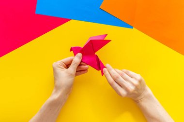Origami kuşu dişi ellerde. Barışa önem ver. Üst görünüm