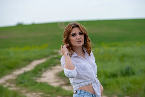白いシャツを着た美しい女が畑でポーズをとって — ストック写真