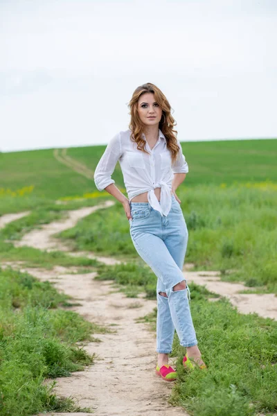 白いシャツを着た女性と畑でポーズをとる青いジーンズ — ストック写真