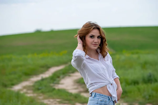 白いシャツを着た美しい女が畑でポーズをとって — ストック写真