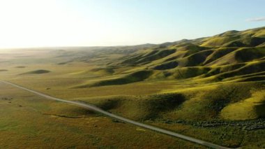 Carrizo Ovası Ulusal Anıt Yörüngesi 'nin solundaki dağ sırtlarında süper gün batımı gölgeleri.