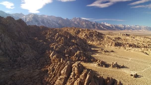アラバマヒルズ砂漠と岩の形成からシエラネバダ山脈とホイットニー山空中ショットバックダウン傾き — ストック動画