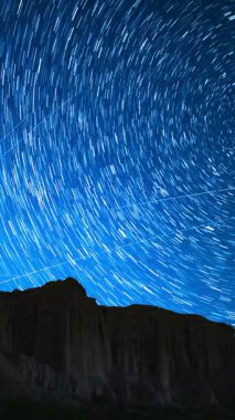 Kaliforniya 'da, Kızıl Kaya Kanyonu' nun yukarısındaki Yıldızlı Gökyüzü Kutup Yıldızı İzleri 'nin dikey Çekimi.