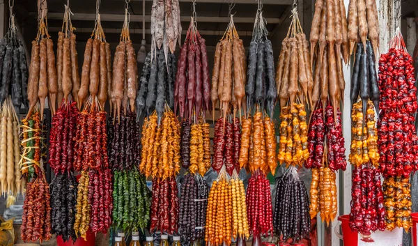Kilise kilisesinin canlı bir düzeni, geleneksel Gürcü tatlıları, asılı, renk yelpazesi sergiliyor. Kalın üzüm suyuna batırılmış fındıktan yapılmış..