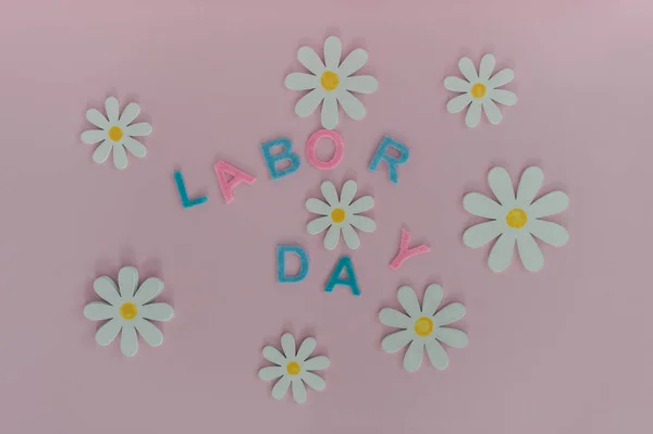 The inscription labor Day on a beautiful pink background. Holida