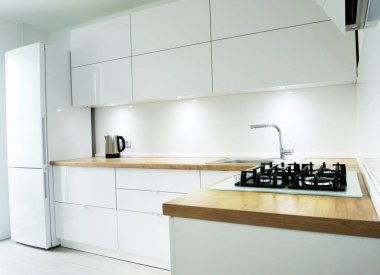 Beyaz lüks mutfak görünümü araçları ve çiçeklerle, modern mutfak araçları beyaz duvarlı yıkama havza ve gaz Ocak bağlı duvar, yeşil çiçek vazo masada mükemmel yıldırım için.