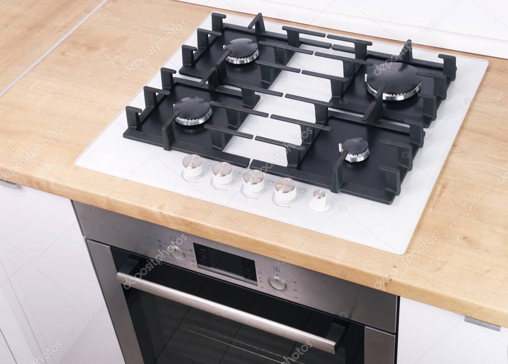 Burners on a white glass gas cooker in the kitchen. View from above.