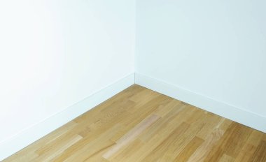 Beyaz duvarlı parke zemin, odanın köşesi.