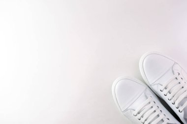 Beyaz arka planda beyaz deri bir çift spor ayakkabı. Yukarıdan görüntüle.