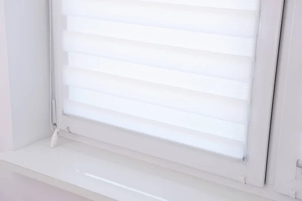 White roller blind on a metal plastic window