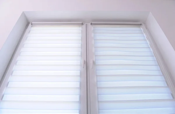 White roller blind on a metal plastic window