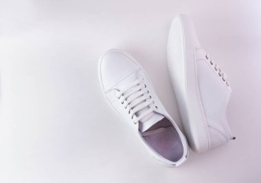 Beyaz arka planda beyaz deri ayakkabılar. Metin veya tasarım için fotokopi alanı olan modaya uygun beyaz spor ayakkabılar ya da spor ayakkabılar. Yeni beyaz spor ayakkabıları, tek renkli. Üst ya da düz.
